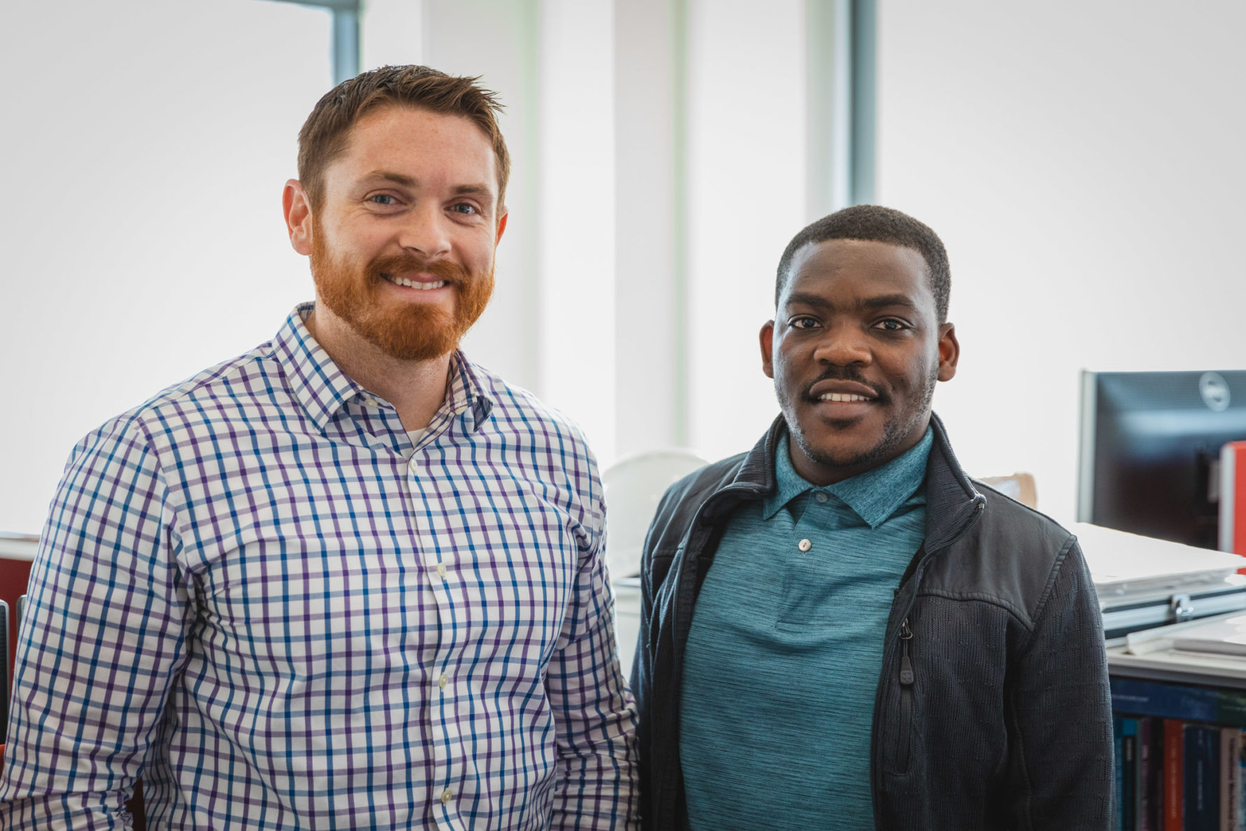 two employees smiling at the camera