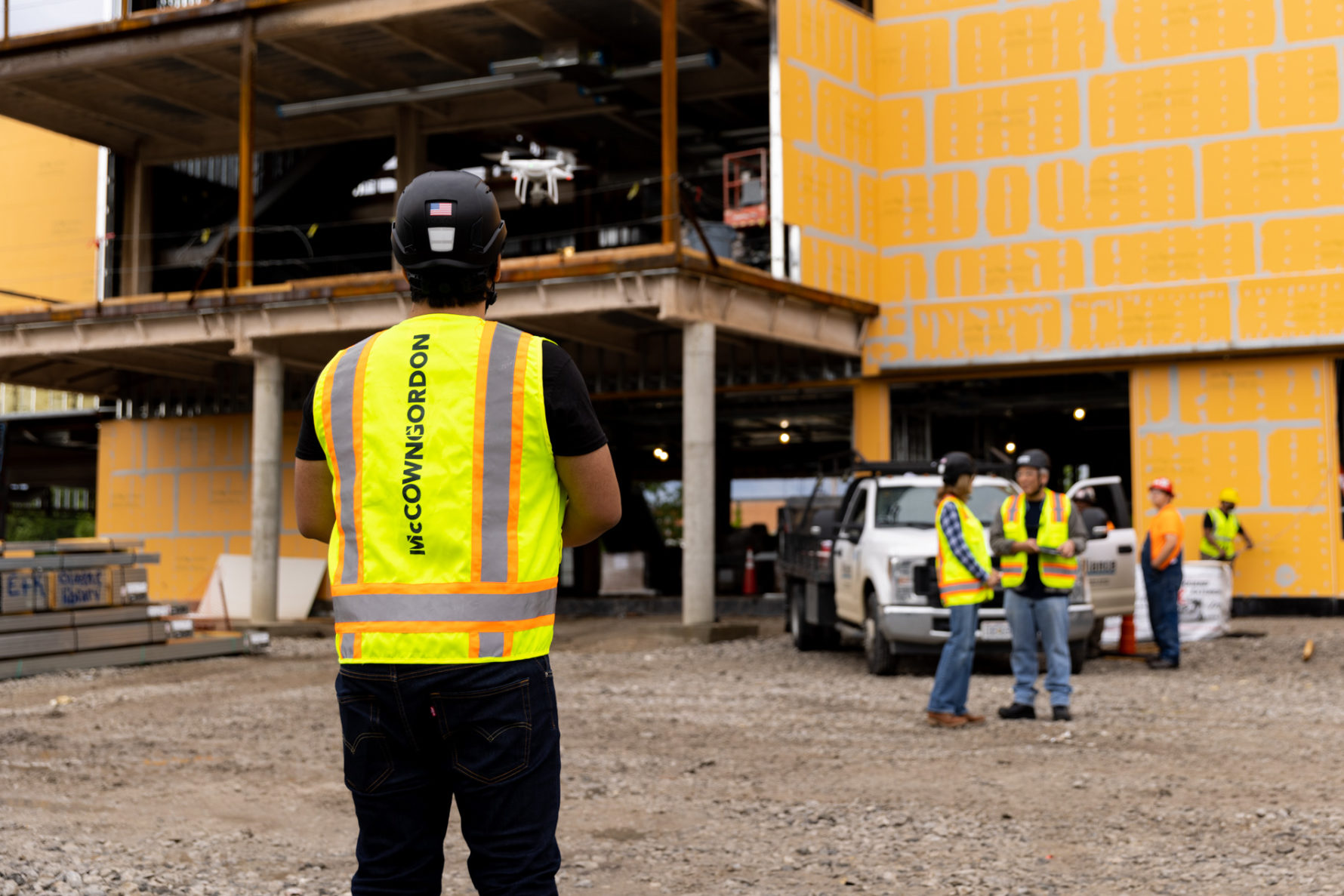 A McCownGordon Construction associate flying a drone on an active job site