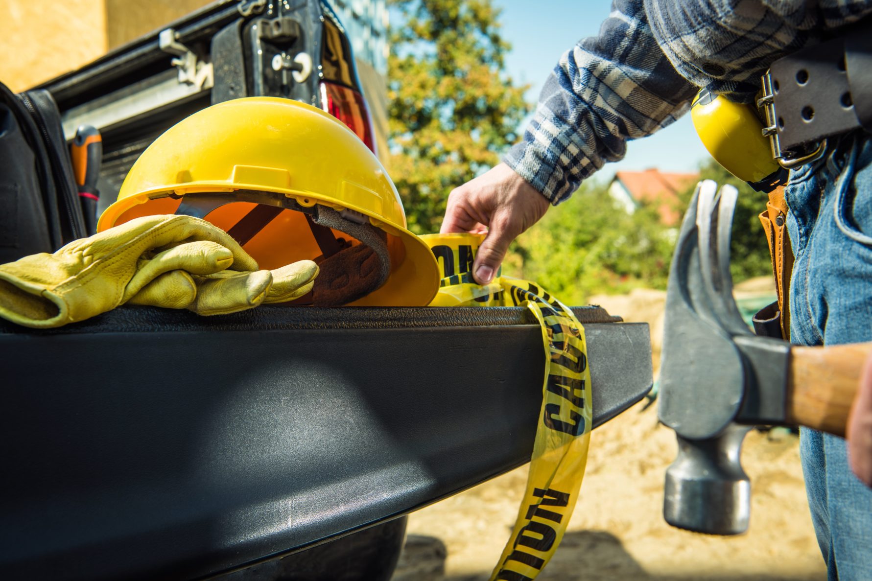 construction tools: hard hat, gloves, toolbelt, hammer and safety tape