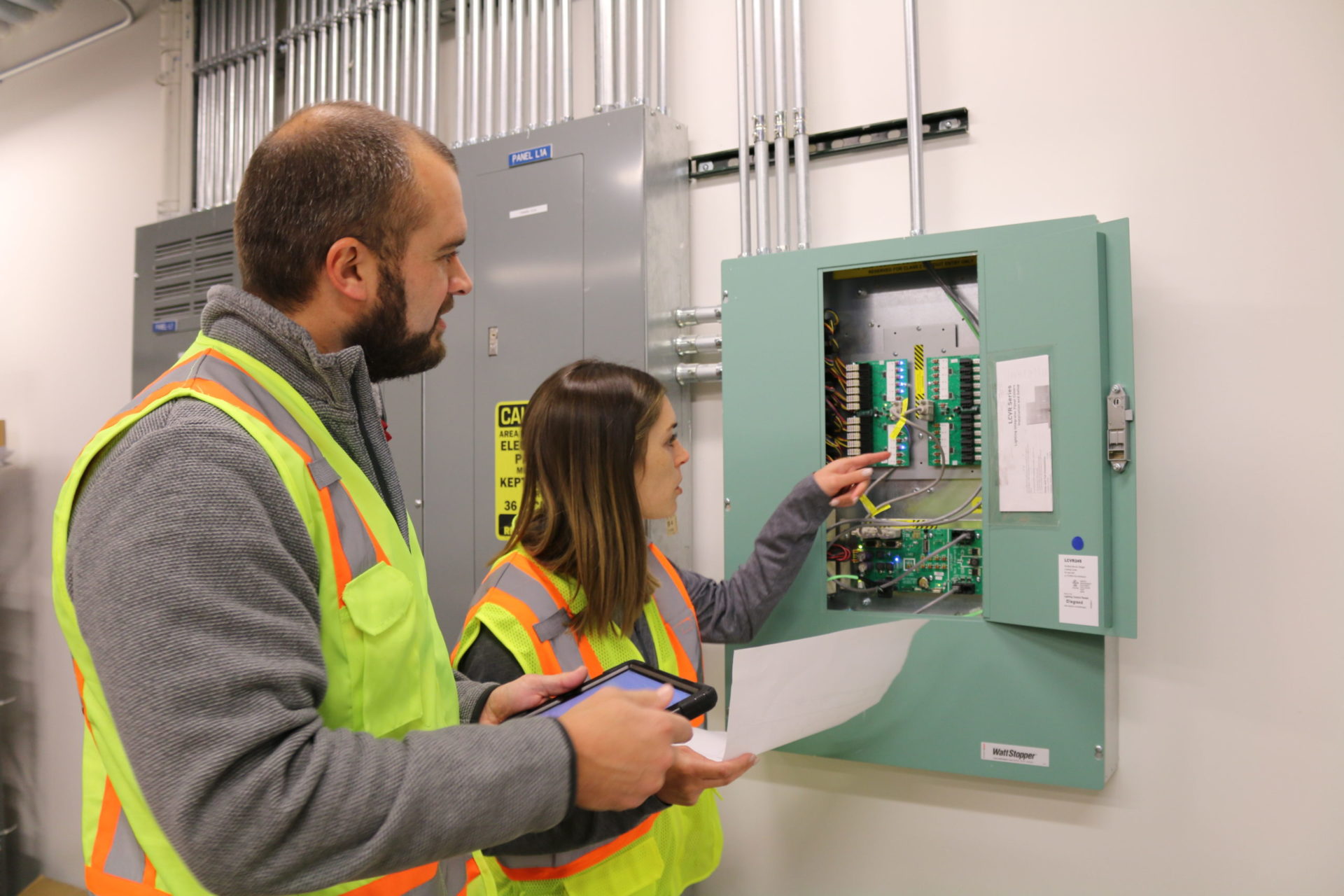 Two McCownGordon Construction workers examining a fuse box