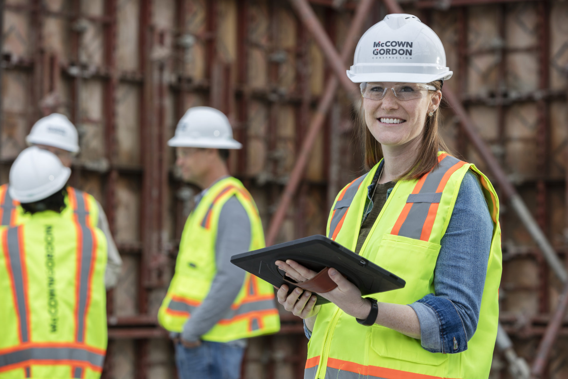 A woman holding an ipad on a McCownGordon Construction jobsite