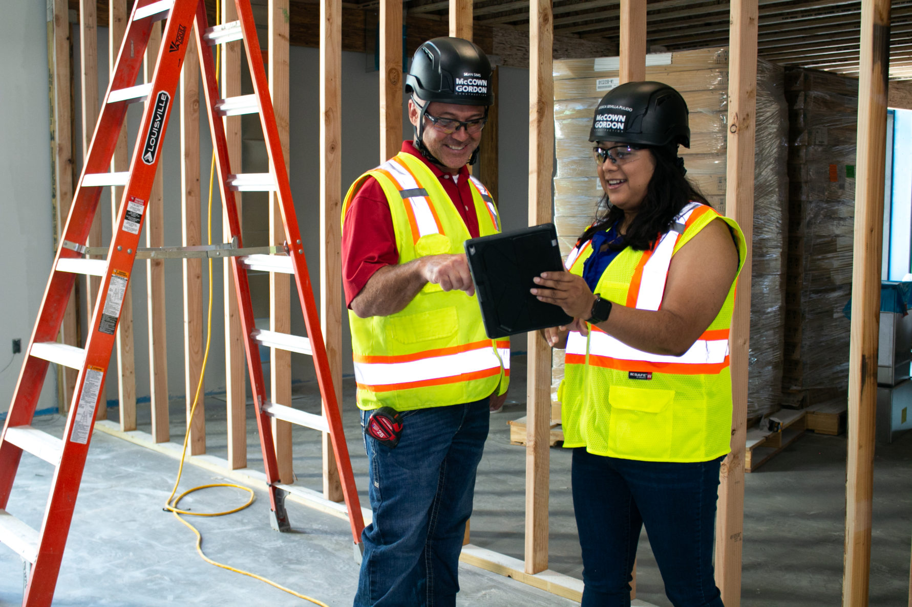 Two McCownGordon Construction associates use technology to check on a project jobsite