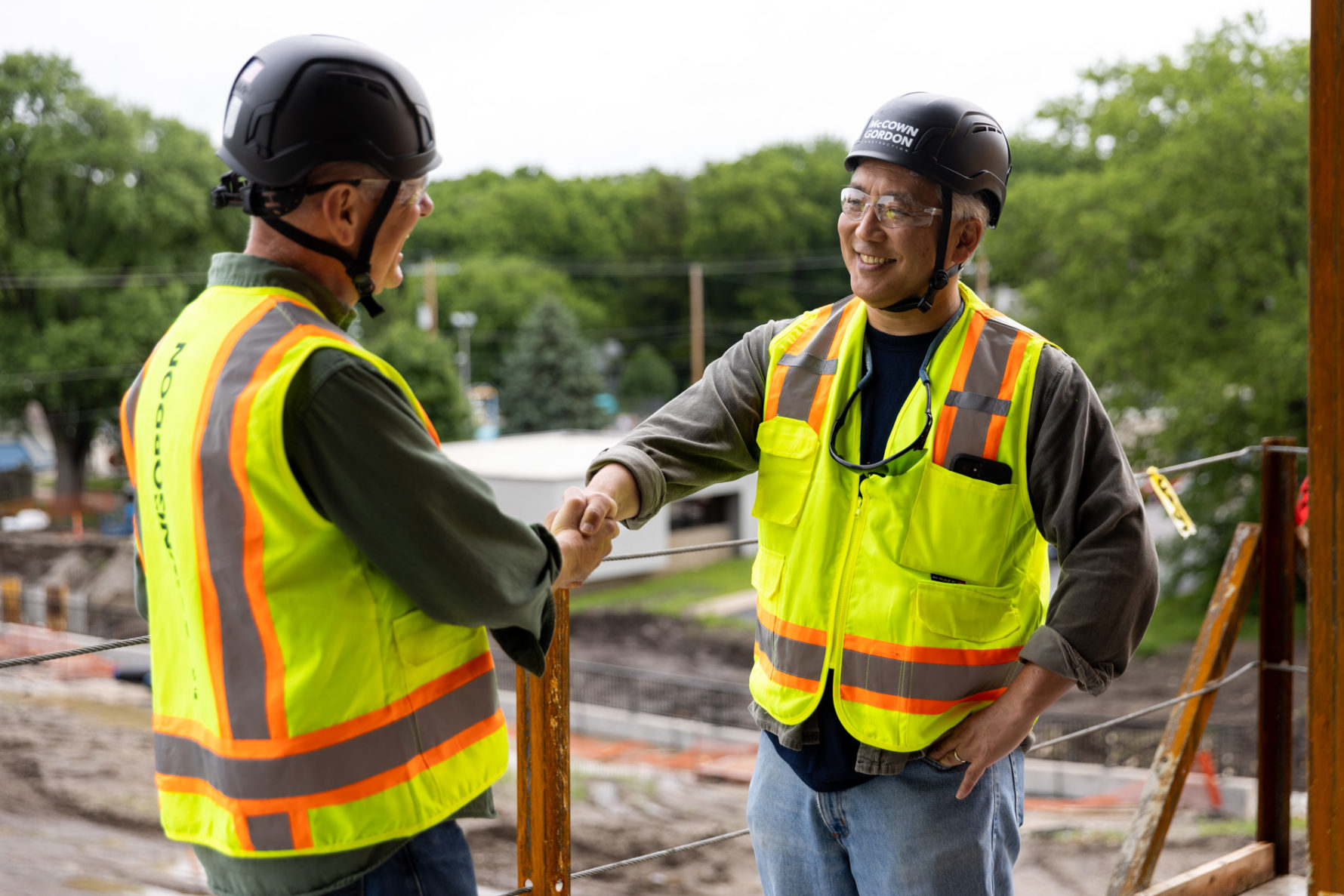 Two McCownGordon associates shaking hands on a construction site