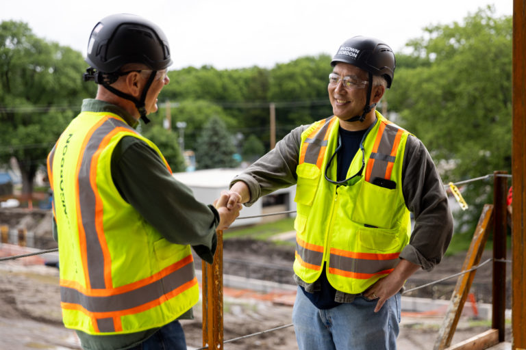 Two McCownGordon associates shaking hands on a construction site