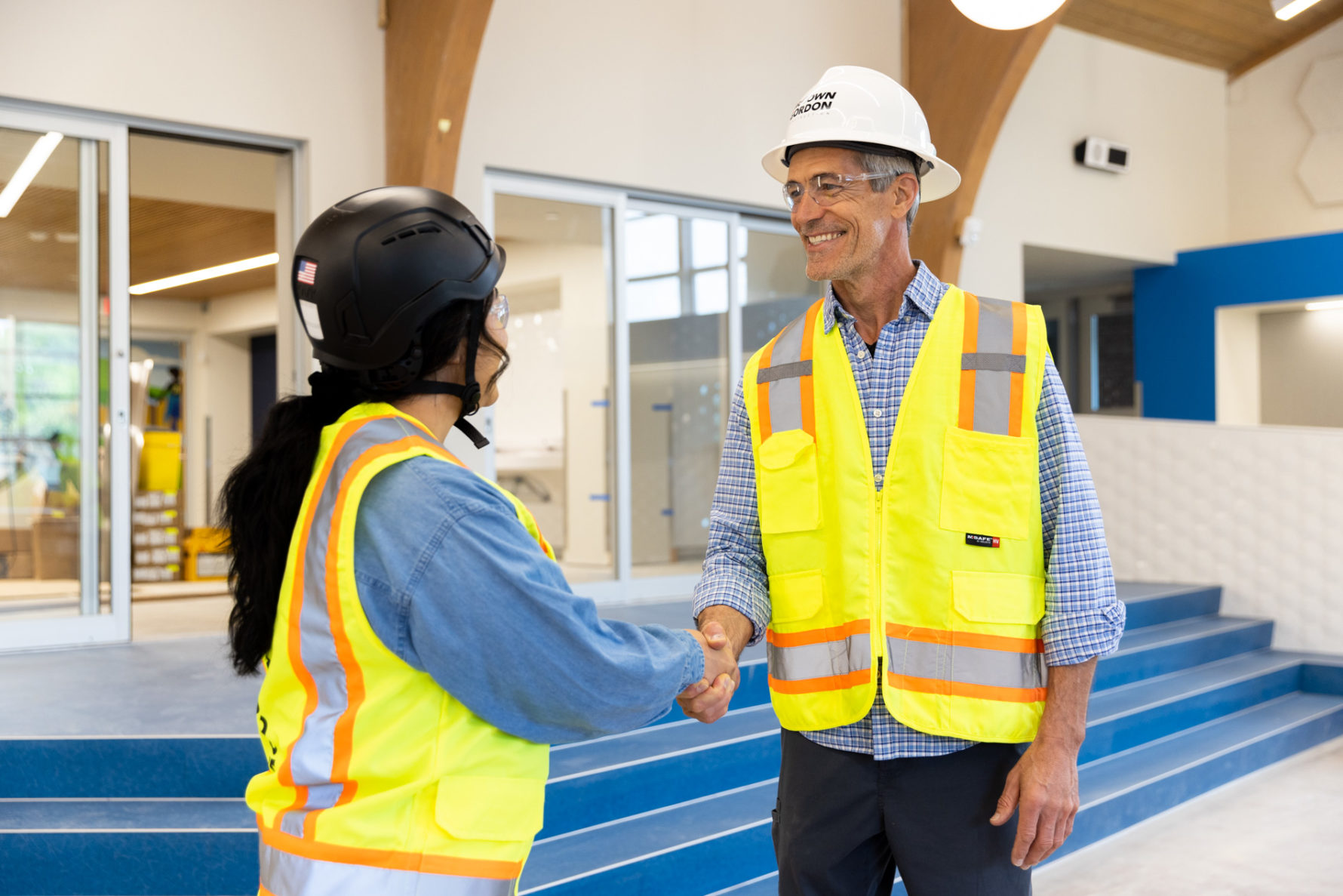 A McCownGordon Construction associate shaking hands with an owner while touring an active job site