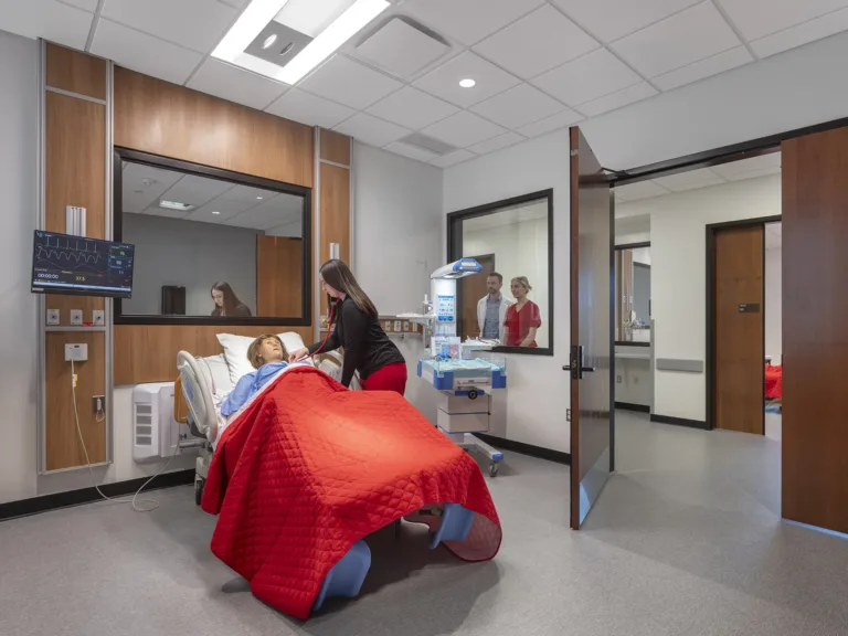 A nurse assisting a fake patient at Pitt State's nursing school, built by McCownGordon Construction