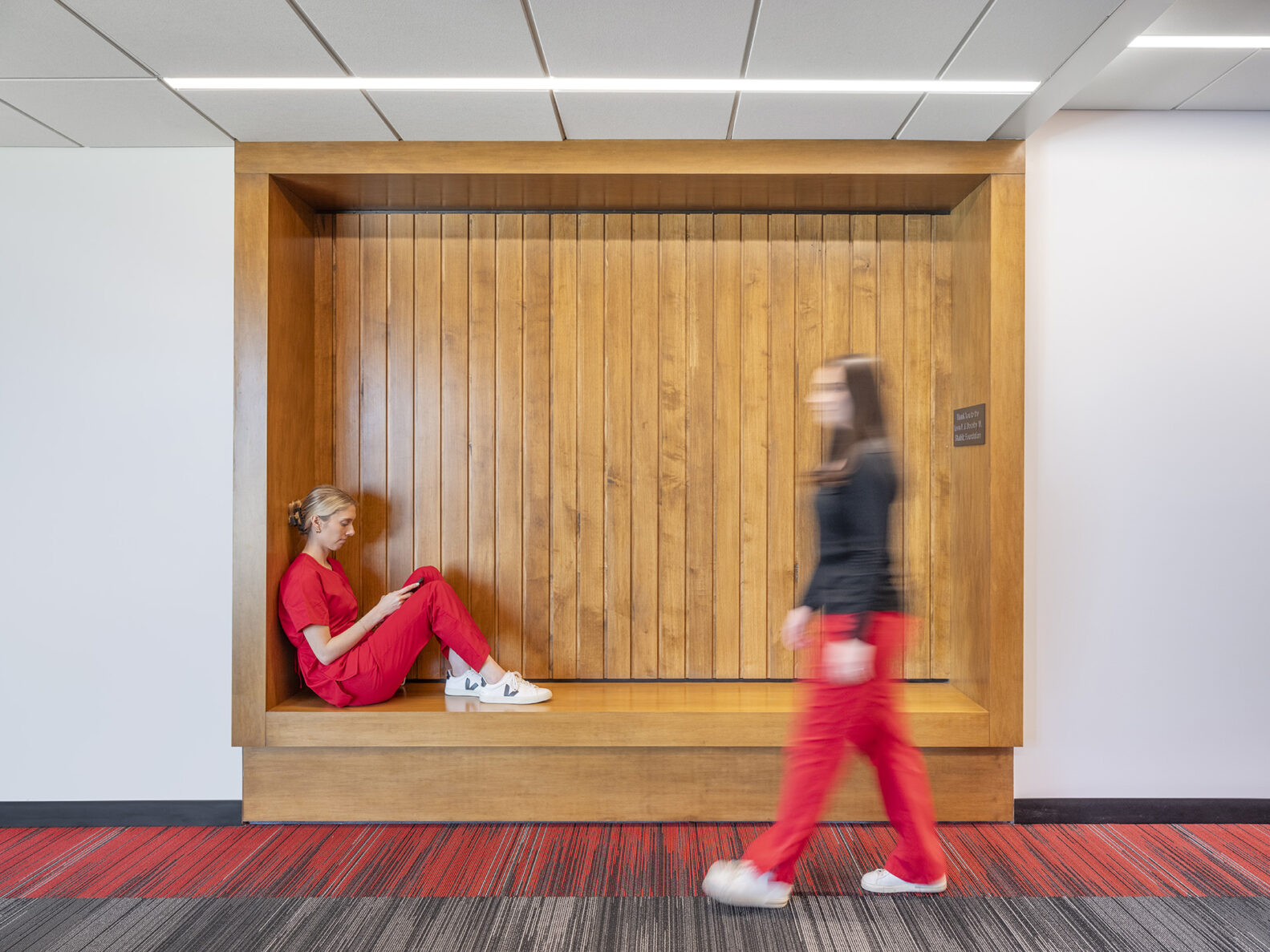 A nursing student walking by a peer in McPherson Hall, Pitt State's nursing school.