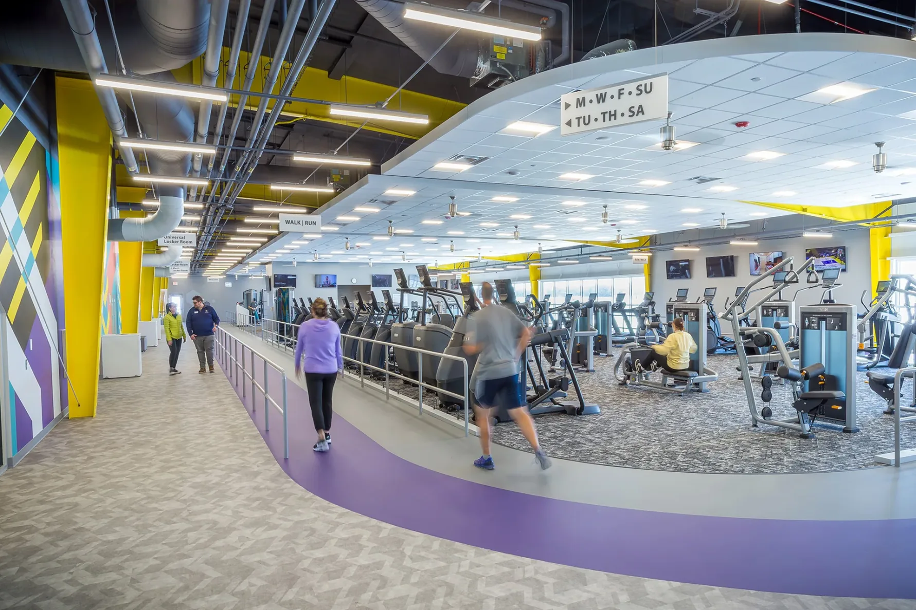 People walking on an indoor track around fitness equipment at the Valley Center Recreation Center