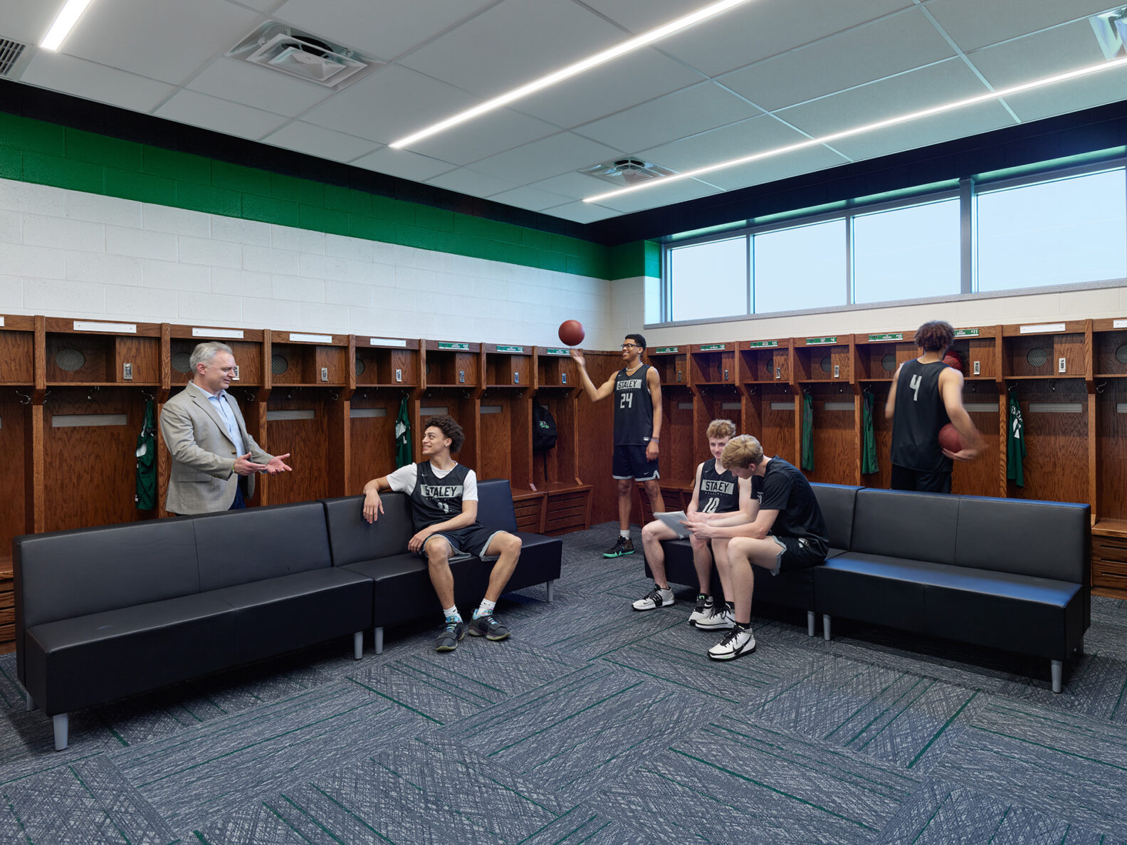 High school basketball team talking in their locker room.