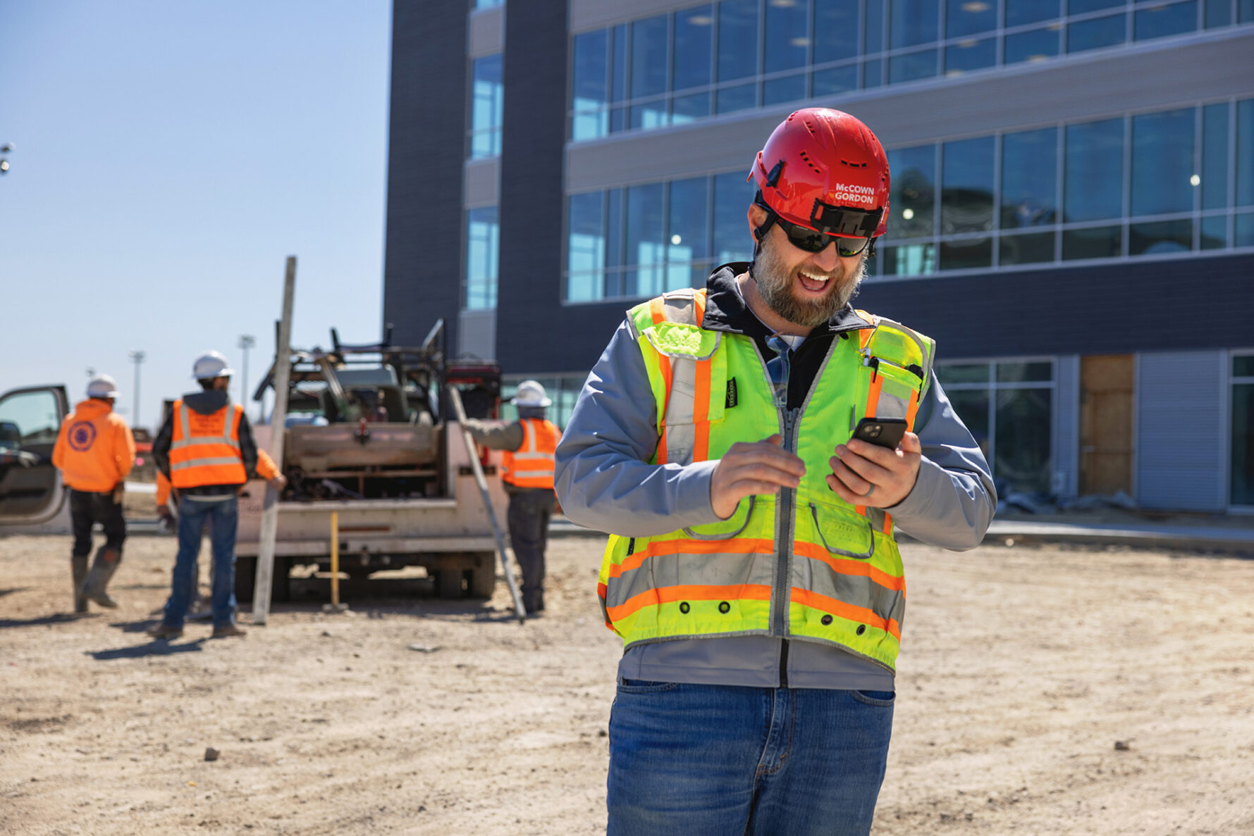 McCownGordon associate looking at phone on a construction site in Manhattan, Kansas