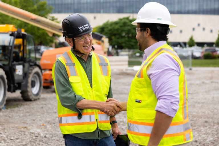 A McCownGordon Construction associate shaking hands with an owner on a job site